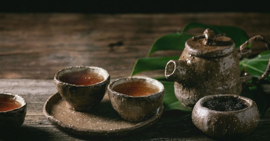 Schwarzer Tee in typischen Tassen mit Teekanne